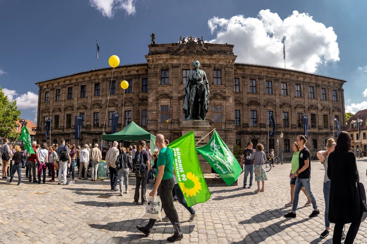 Demonstration at Erlangen University in Germany with flags and crowd.