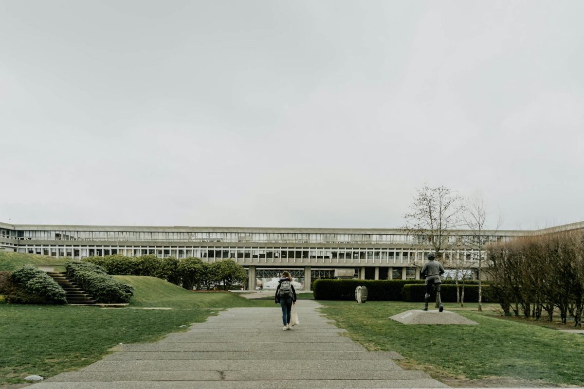 Woman walking towards the main building at Simon Fraser University in Burnaby, BC, Canada.