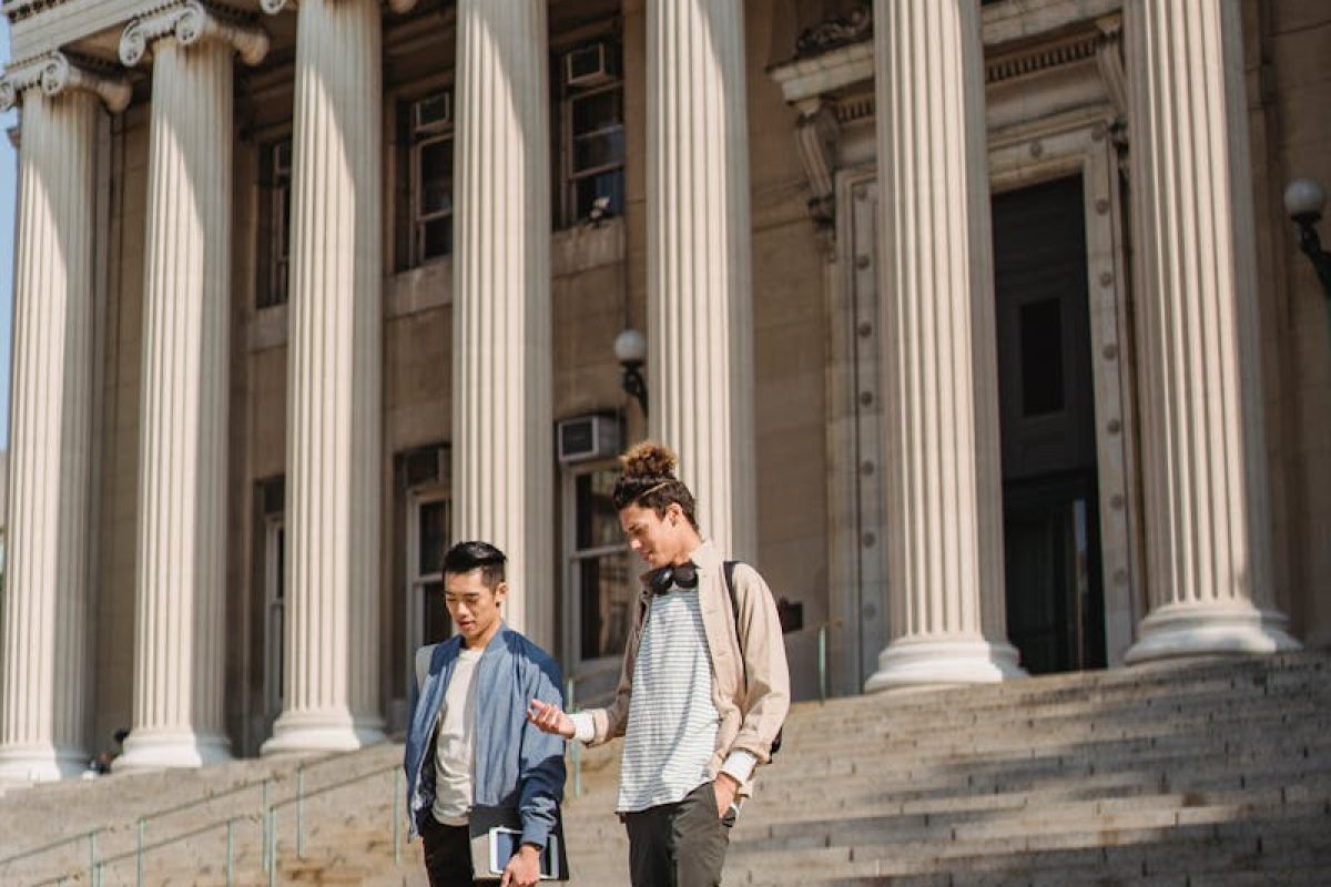 Two young men descend steps at Columbia University, showcasing campus life and education themes.