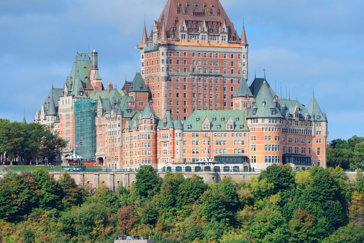 Quebec City skyline over river with blue sky and cloud.