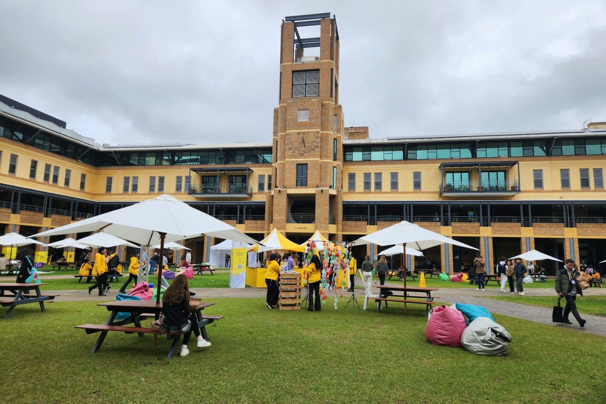 A group of people sitting on top of a lush green field