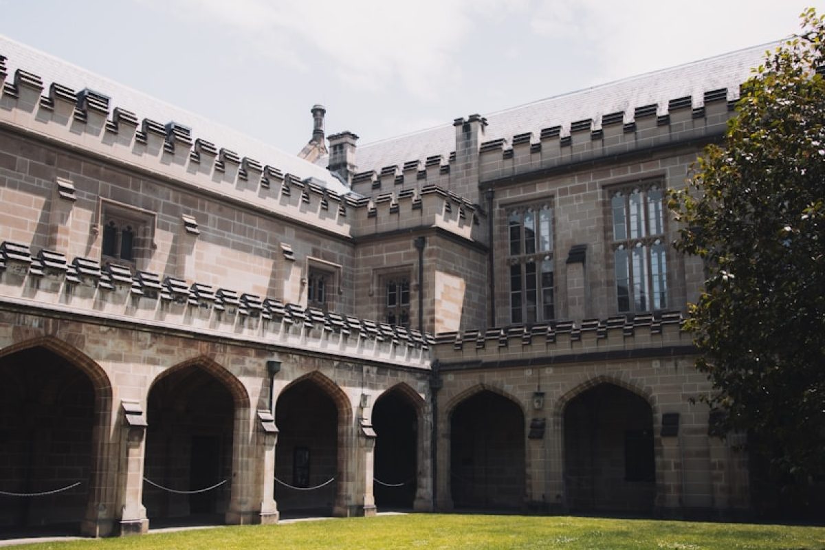 white concrete building under white clouds during daytime